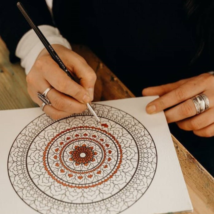 a person painting mandala