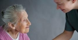 Young carer holding older women hand